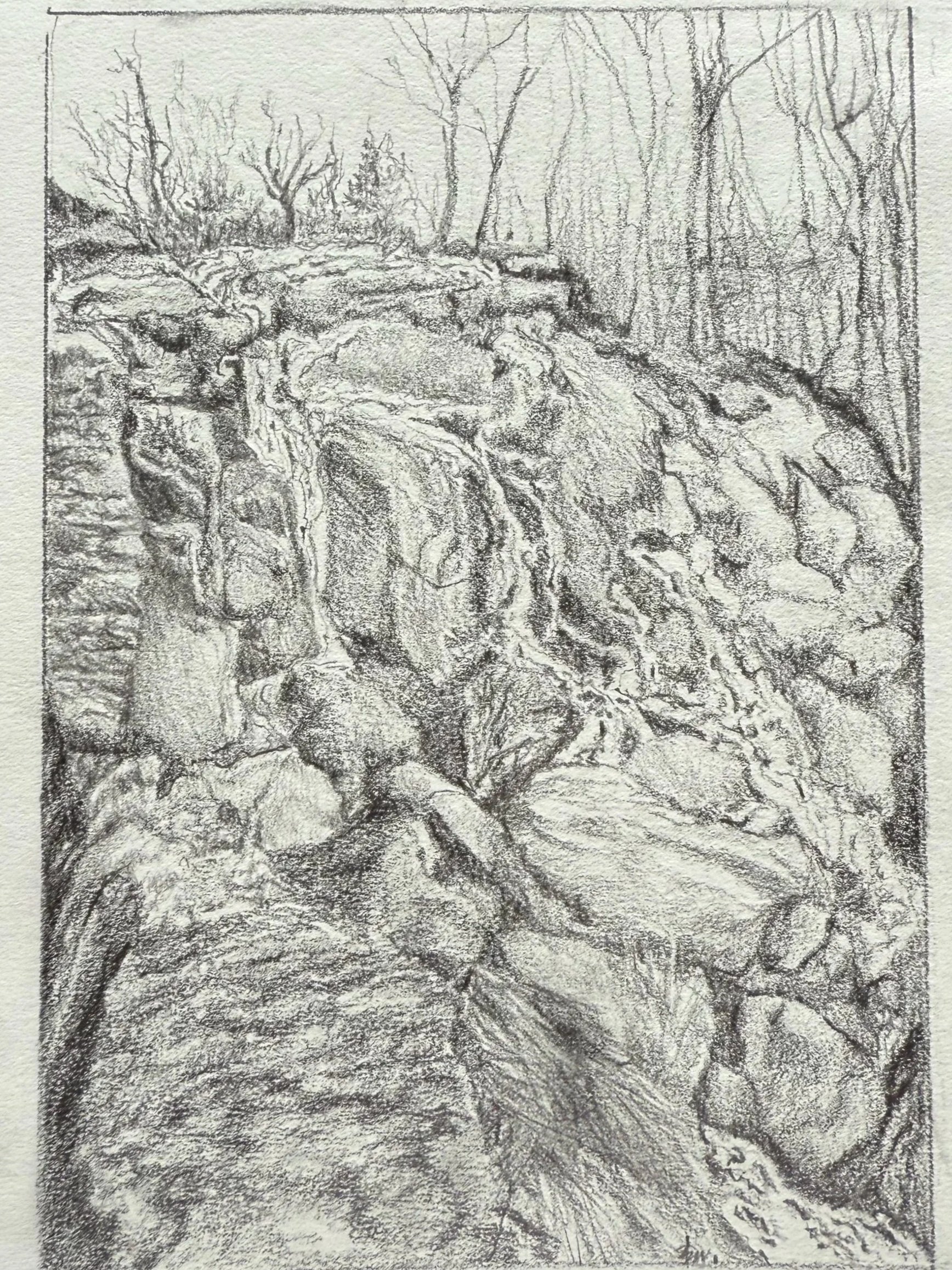 A detailed pencil sketch of a rocky stream flowing through a wooded area with bare trees in the background.