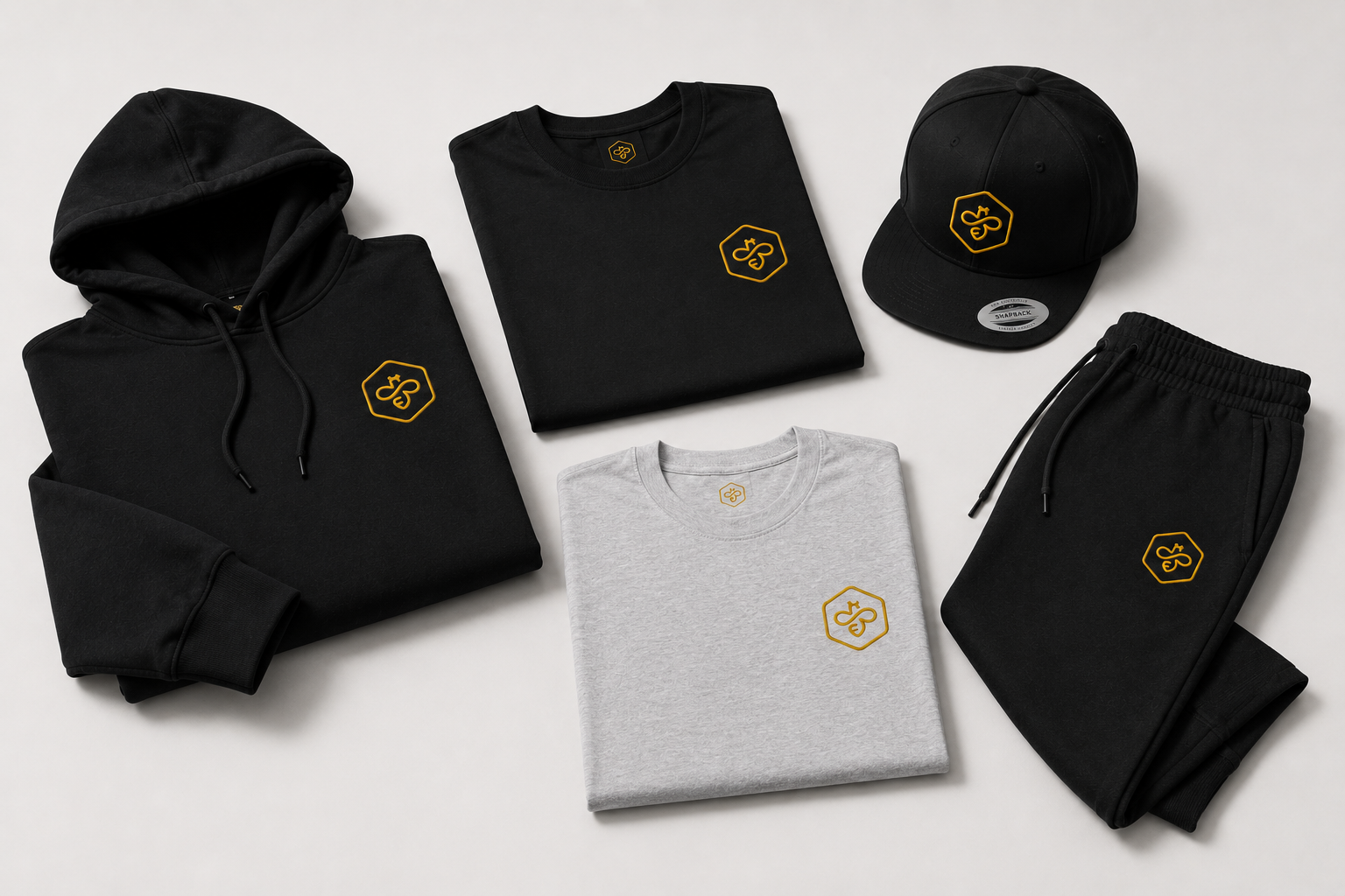 Collection of black and gray clothing items with a yellow and black logo, including a hoodie, T-shirt, cap, sweatpants, and a crewneck, arranged on a white surface.