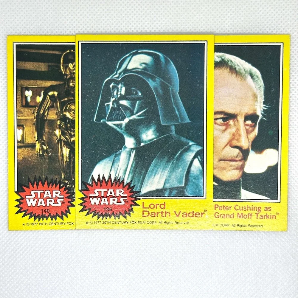 Star Wars collectible cards featuring images of Darth Vader and Grand Moff Tarkin, with text stating 'Lord Darth Vader' and 'Peter Cushing as Grand Moff Tarkin'.