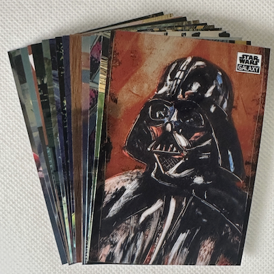 A collection of Star Wars cards, with the top one featuring Darth Vader on the card.