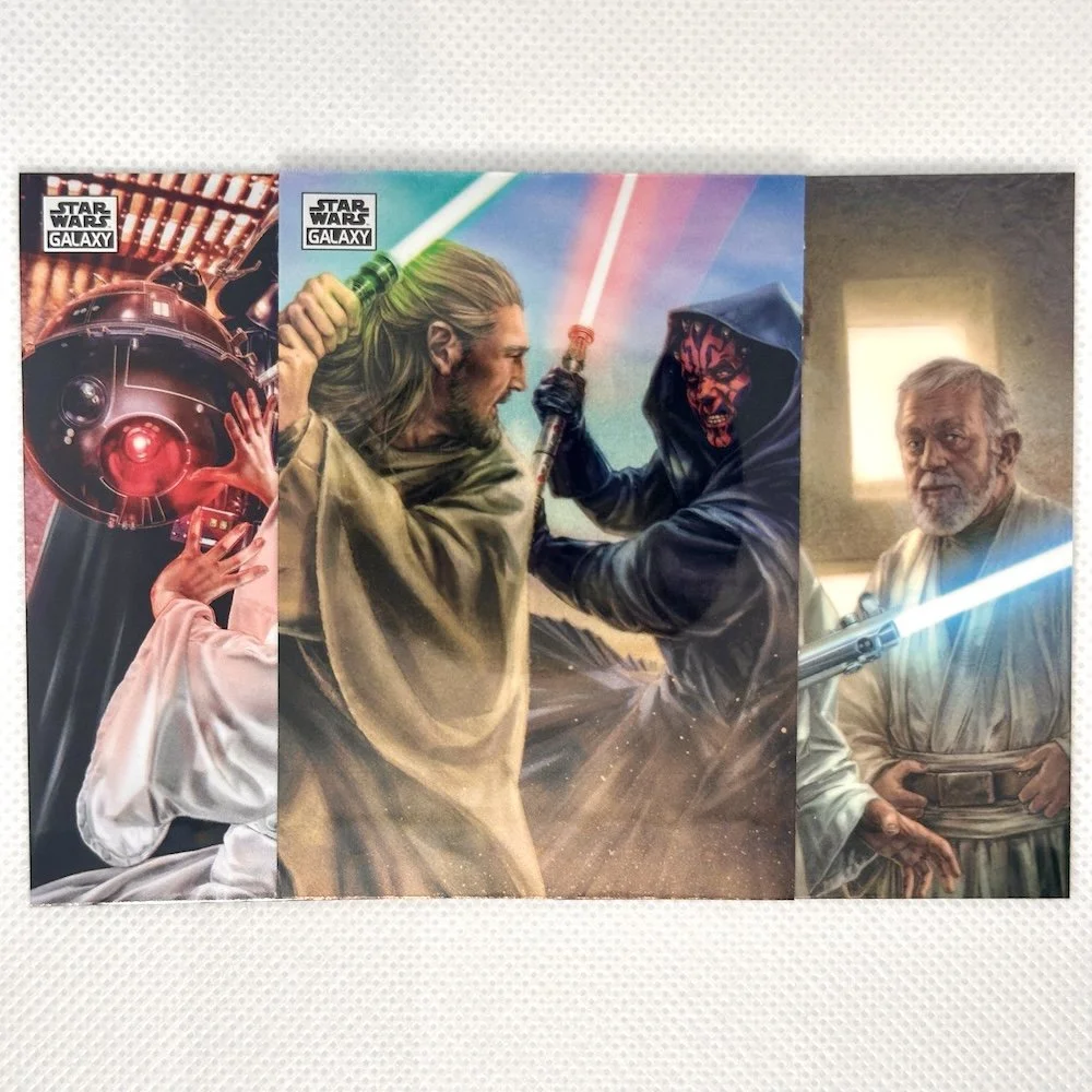 Colorful cards featuring characters from Star Wars, including a person holding a lightsaber, a dark figure with a red lightsaber, and an older man with a blue lightsaber.