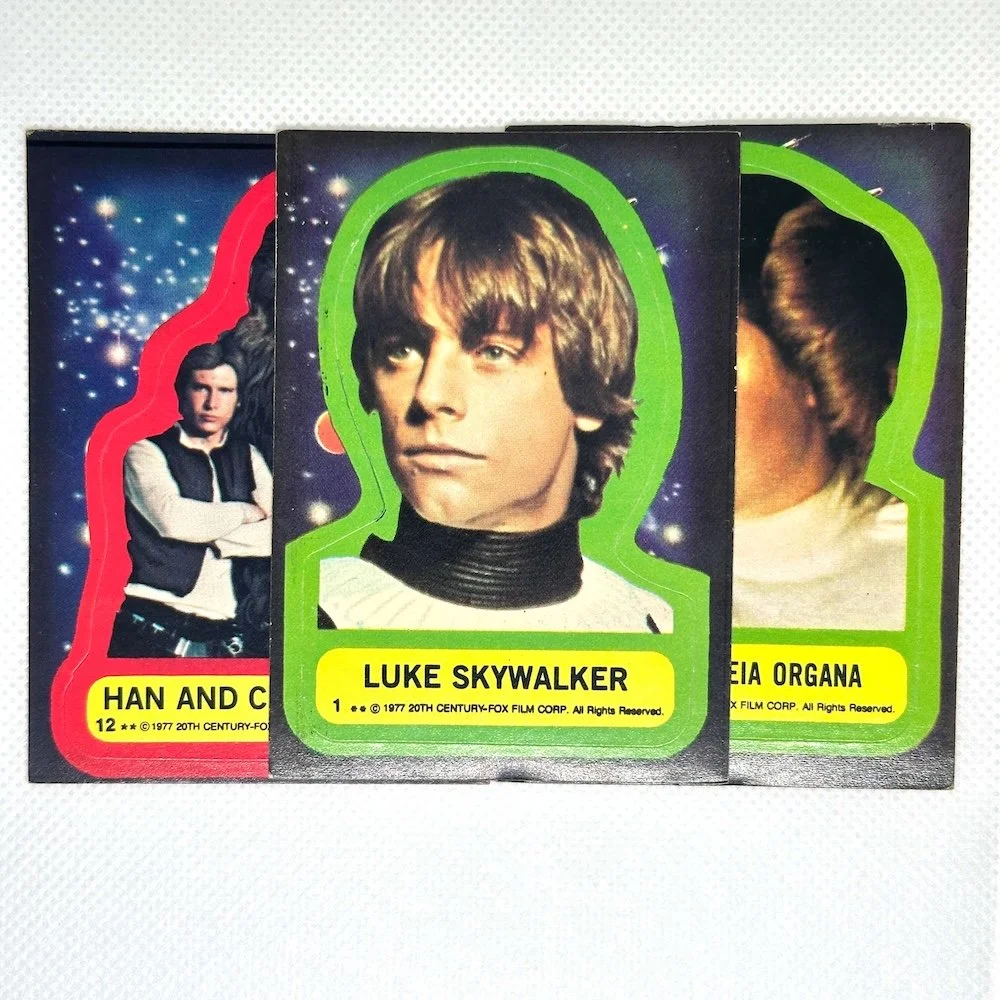 Three vintage Star Wars collectible cards featuring Han Solo, Luke Skywalker, and Princess Leia Organa against a space-themed background.