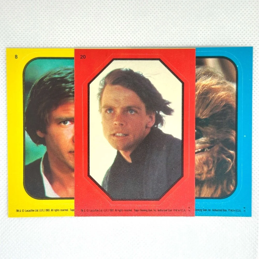 Colorful trading cards featuring characters from Star Wars, including Han Solo, Luke Skywalker, and Chewbacca.