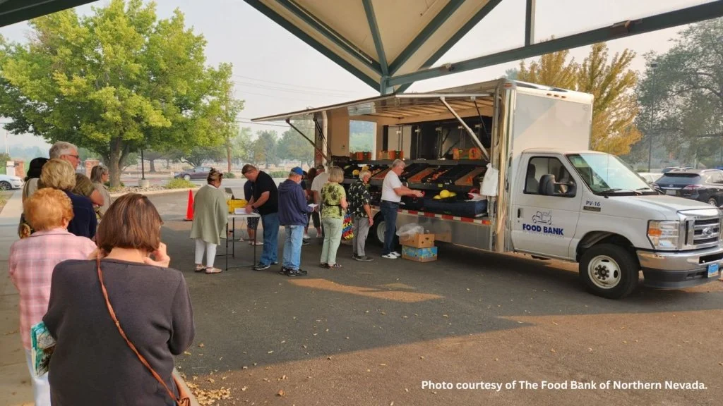 Community members stand in line at a mobile market truck