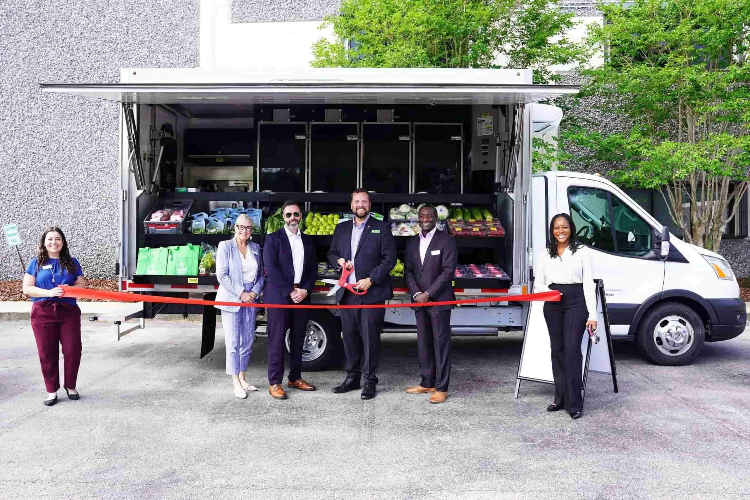 Group cutting a ribbon at the Volusia mobile market launch