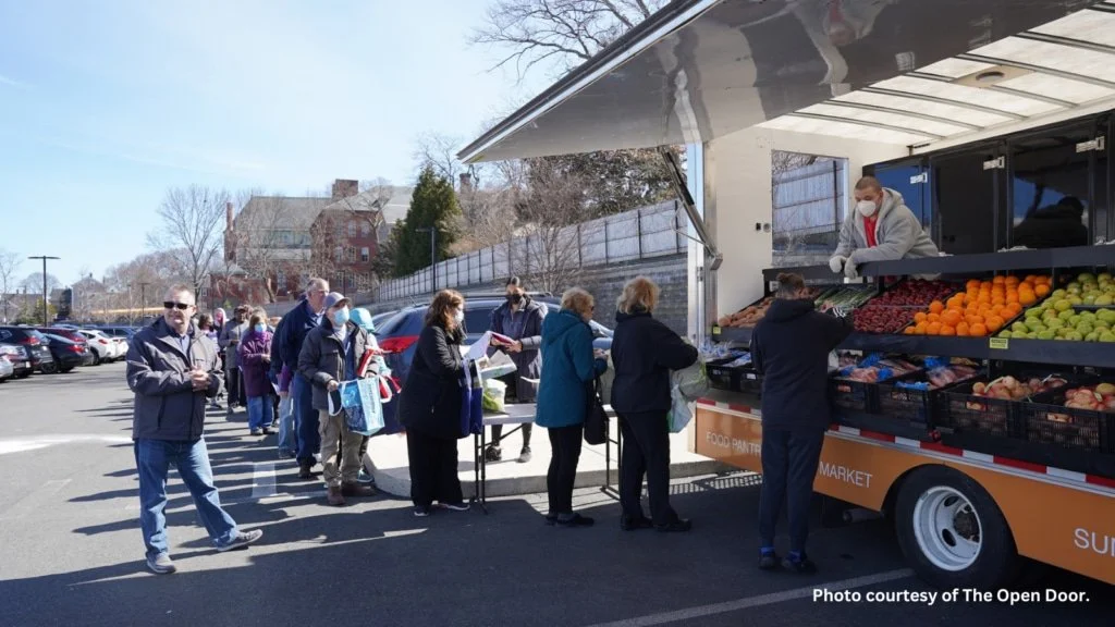 Community members stand in line for produce at a mobile market truck