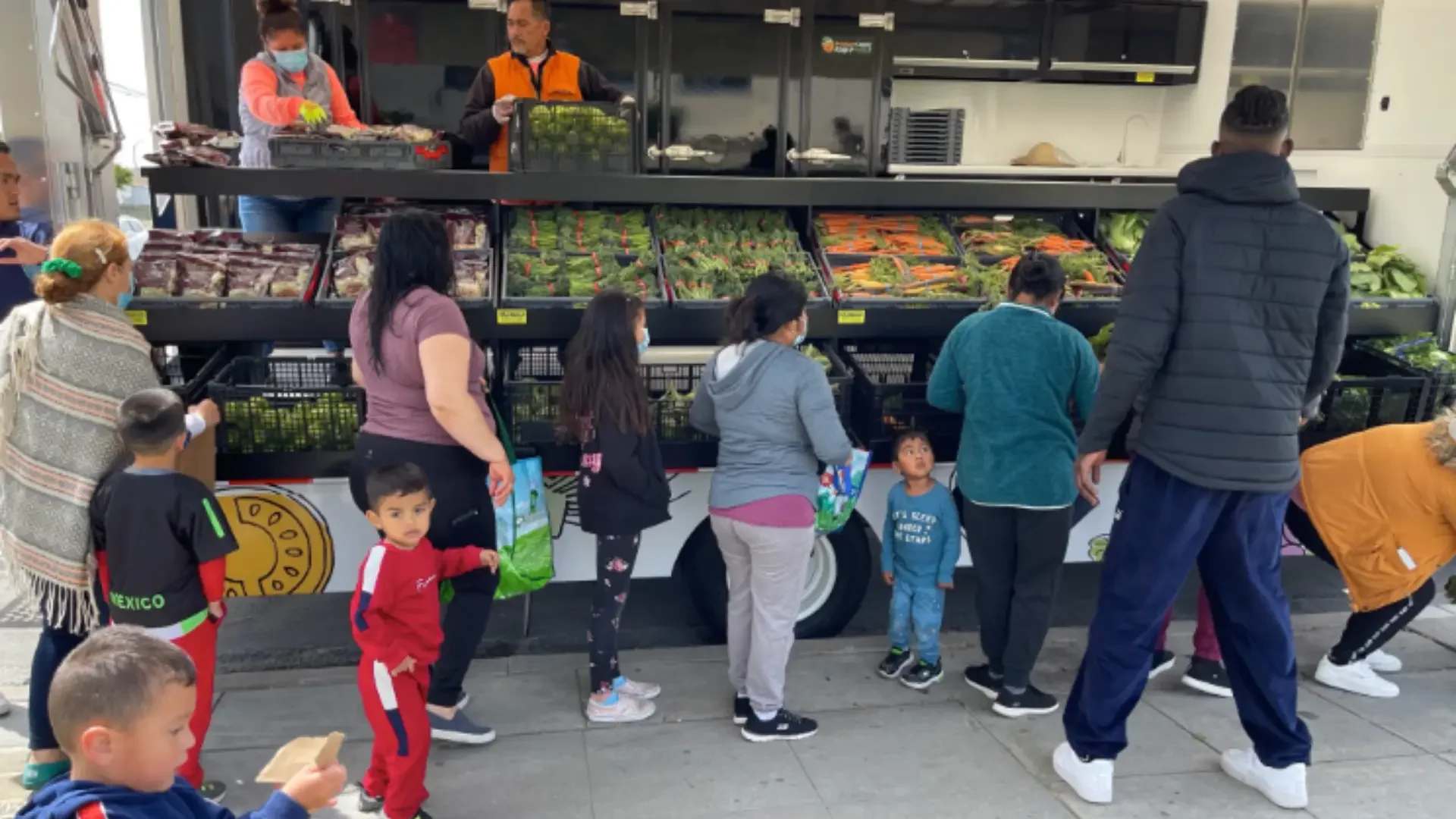 People buying produce from a mobile market truck