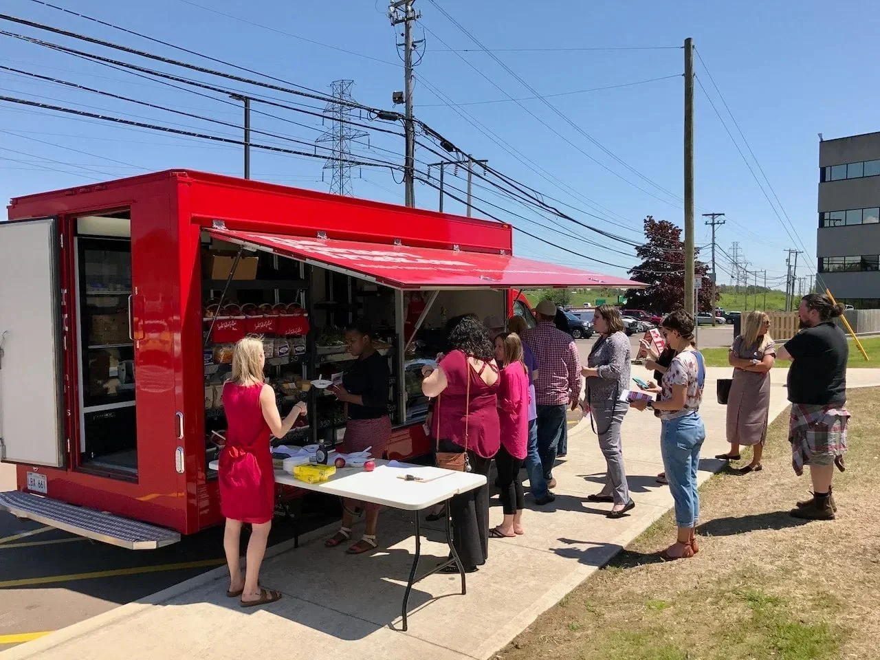 Community members stand in line at a mobile market