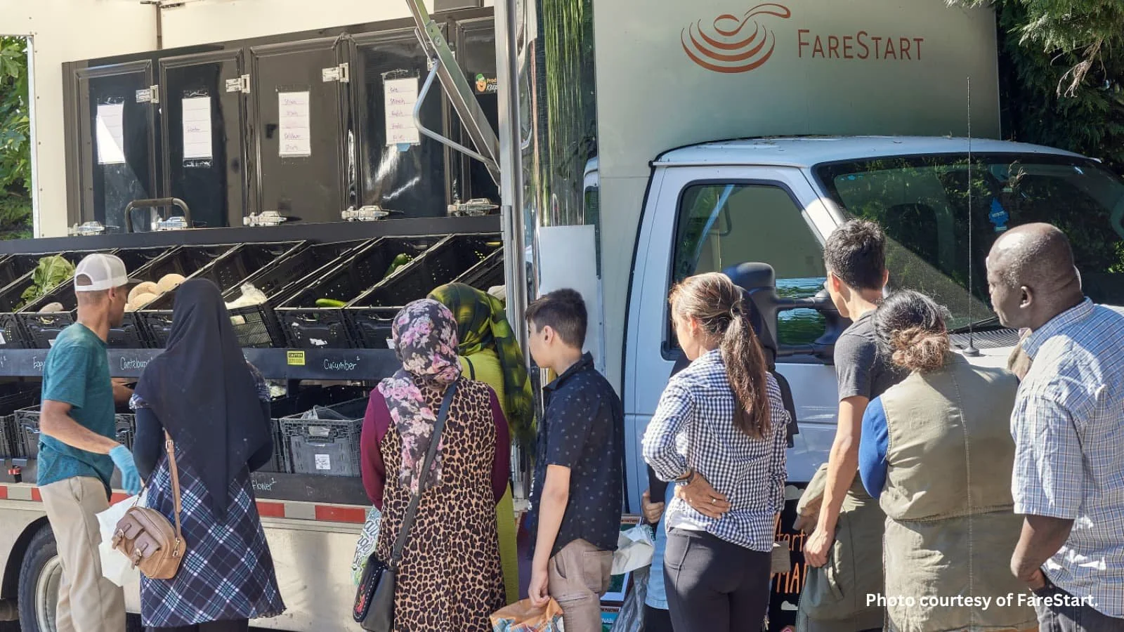 Community members waiting in line at a mobile market truck