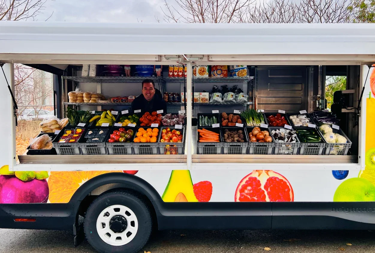 Fred standing inside a mobile market truck with produce