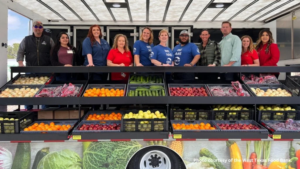 Volunteers and workers pose with produce on a mobile market truck