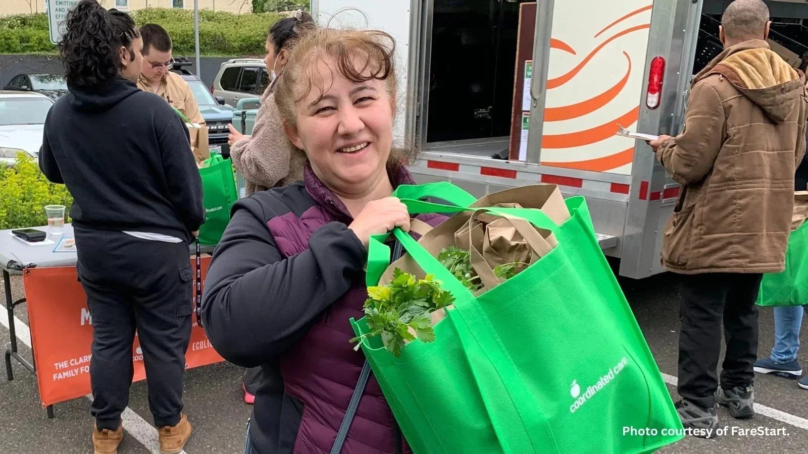 A community member carrying produce from a mobile market