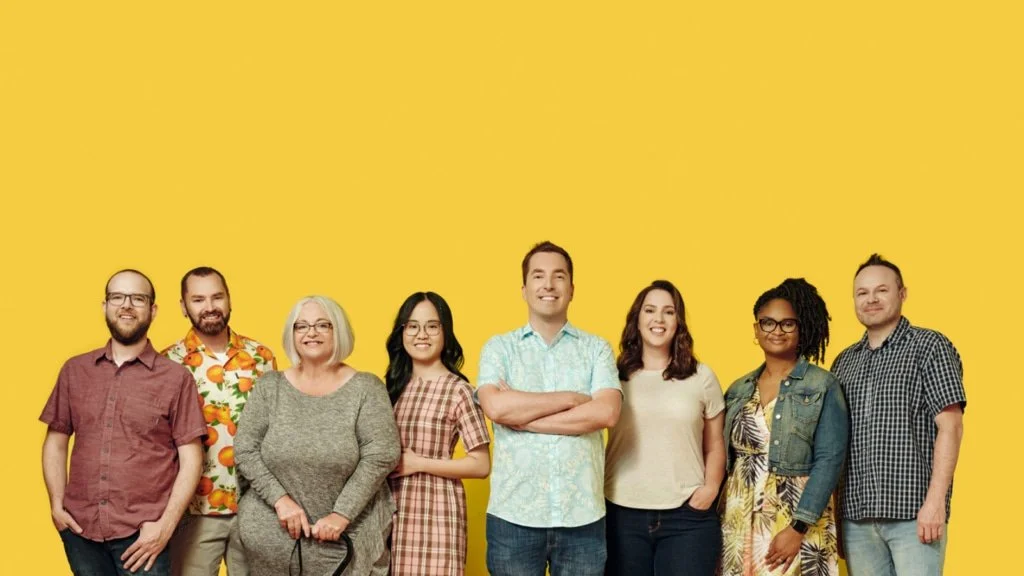 Farmer's Truck staff posing in front of a yellow background