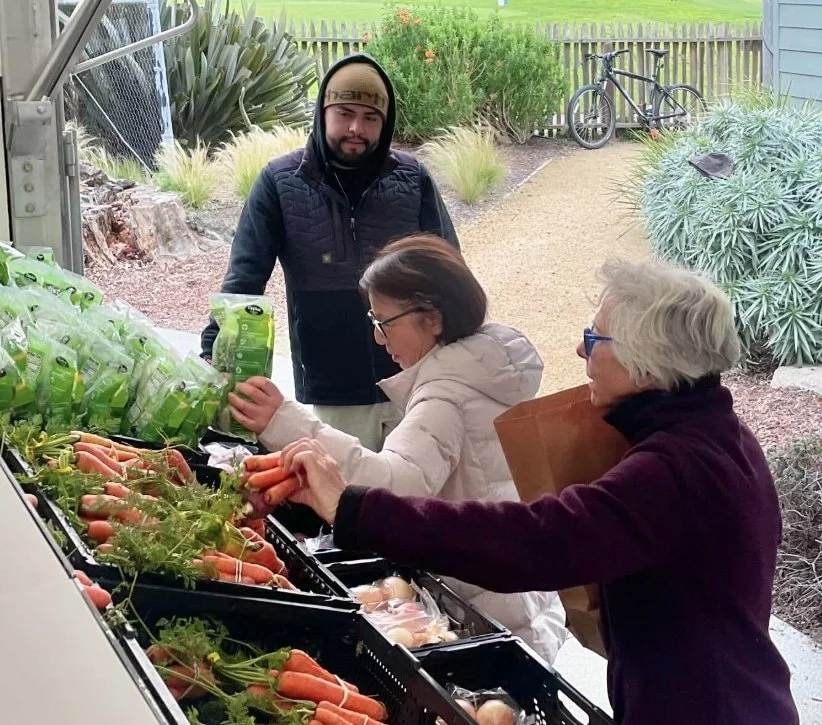 Community members select fresh produce from a mobile market