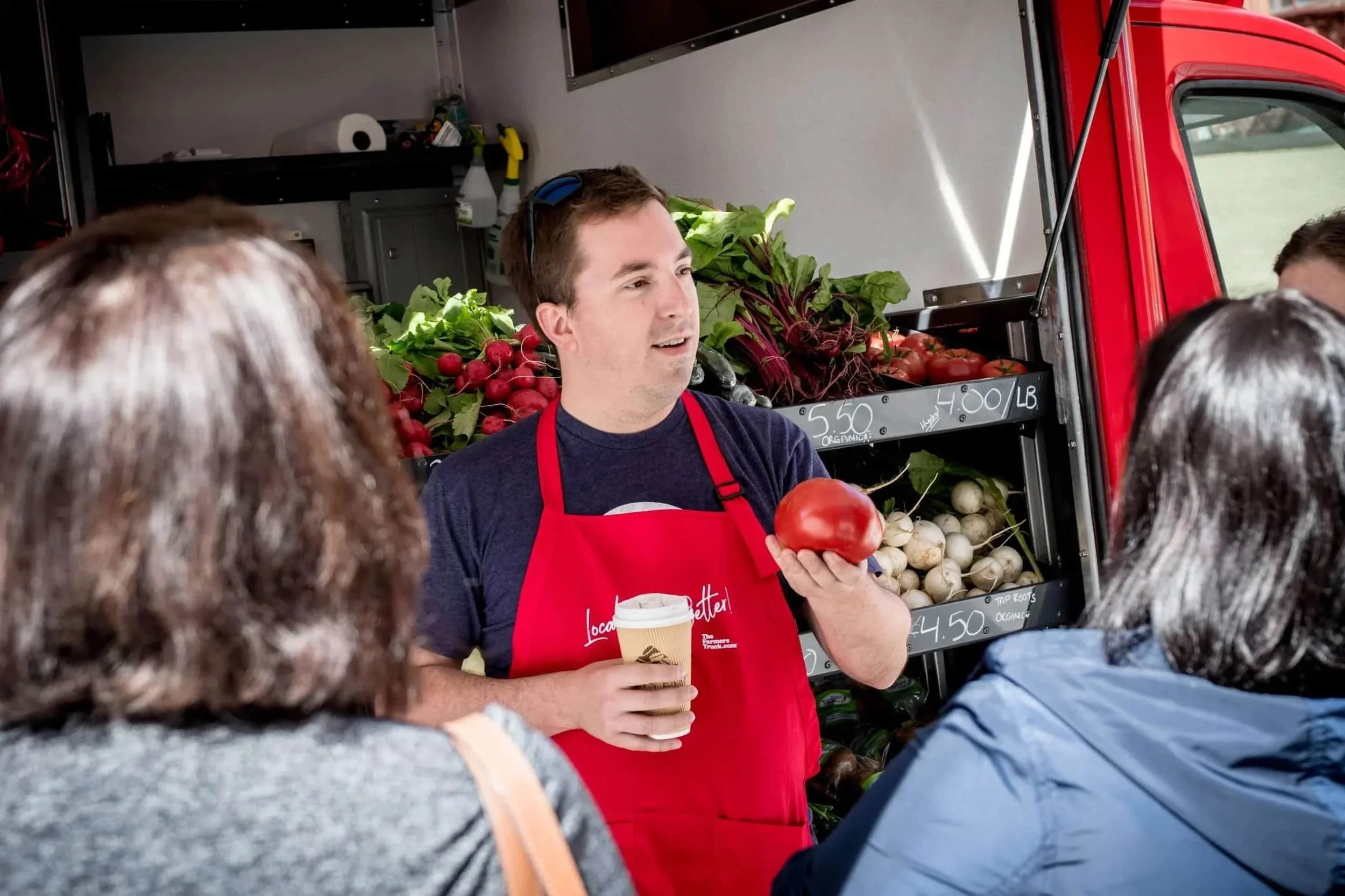 Fred speaking to community members in front of a mobile market