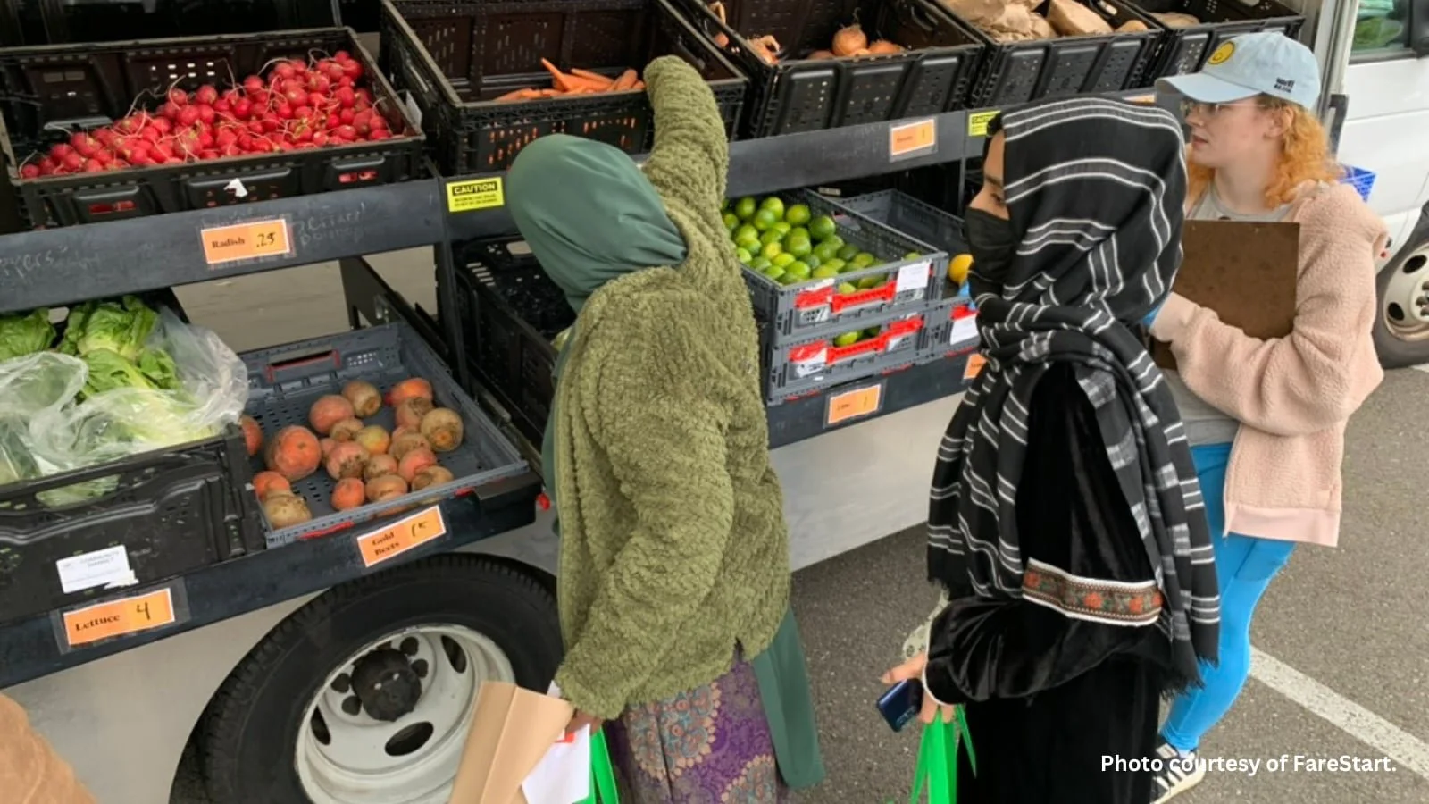 Community members gathering produce at a mobile market truck