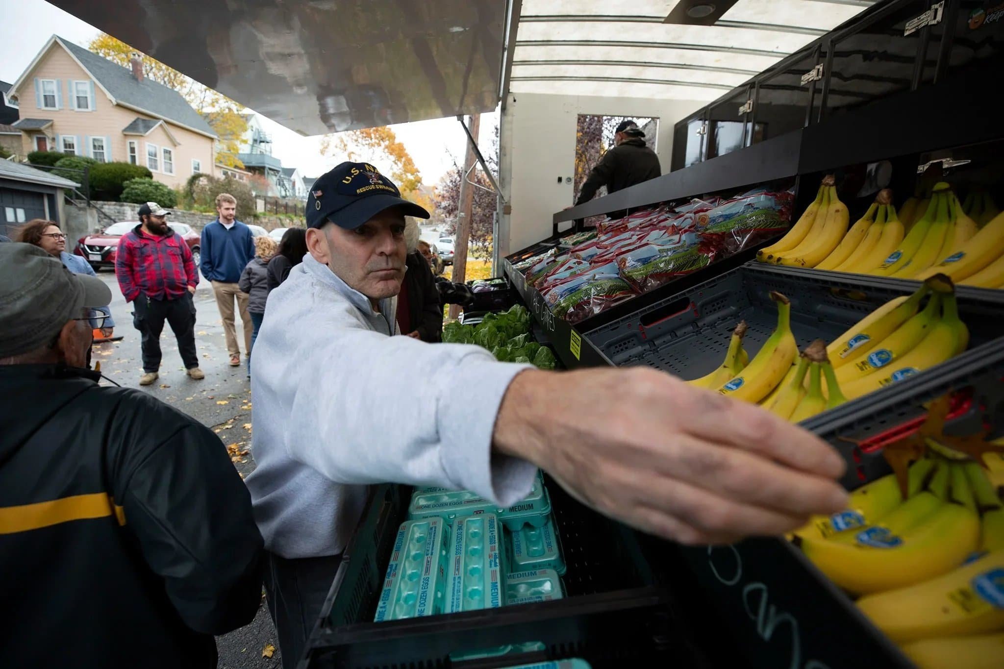 A community member reaches for produce at a mobile market