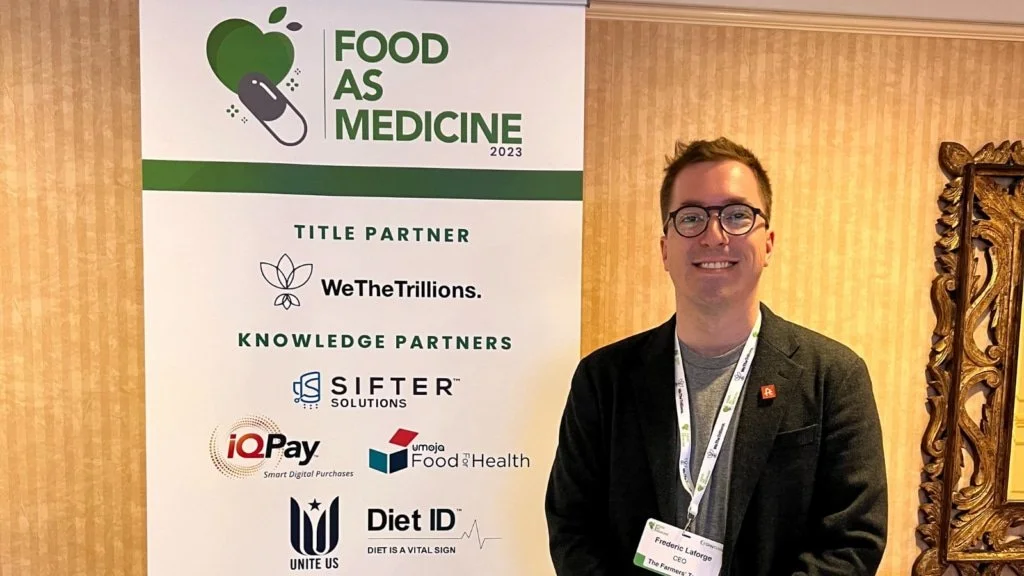 Fred posing in front of a sign at a Food as Medicine event