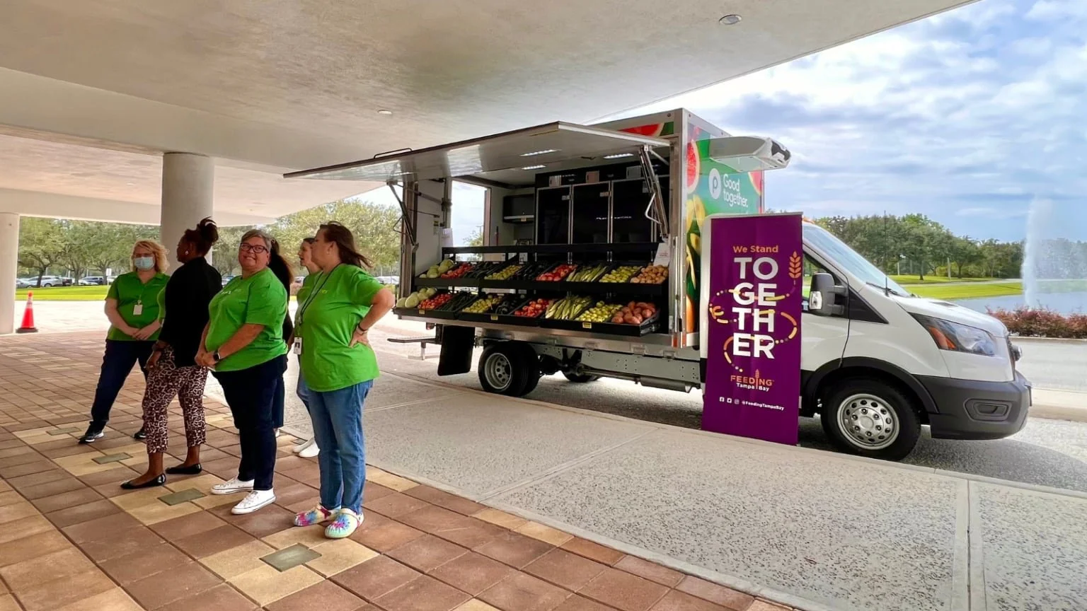 Volunteers standing together in front of a mobile market truck