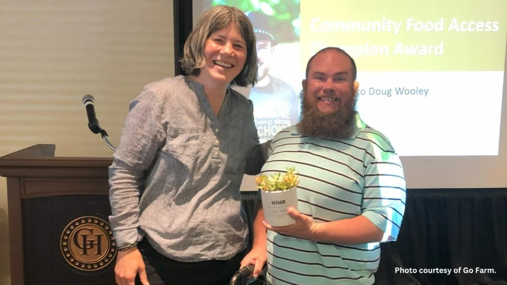 Doug Wooley smiling accepting an award from GoFarm