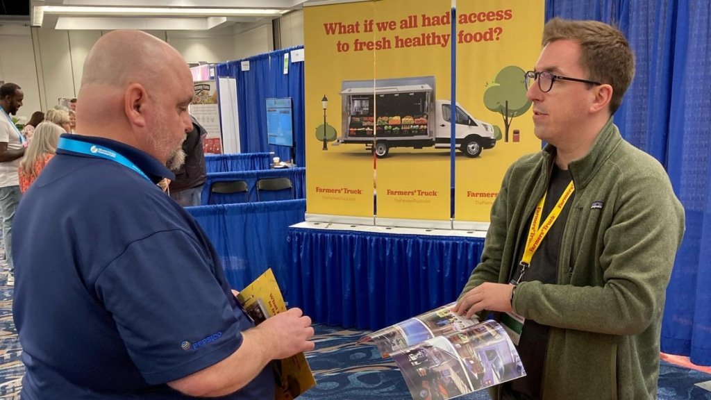 Fred speaking to someone at an event about Farmer's truck mobile markets
