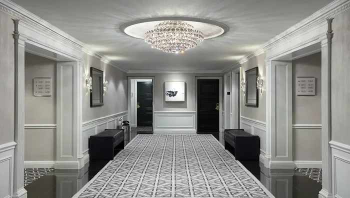 Renovated NYC apartment corridor with modern LED lighting, commercial-grade wallcovering, and durable flooring