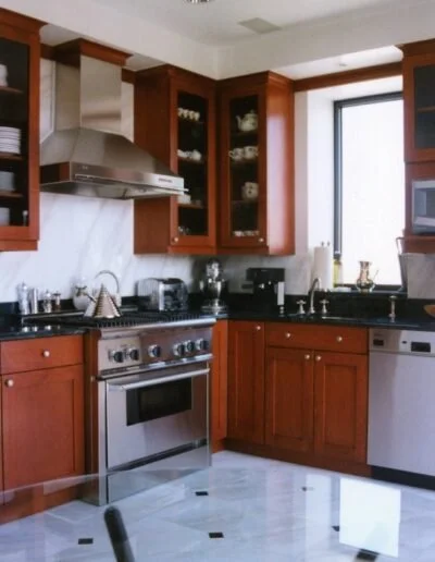 Kitchen with wooden cabinets, stainless steel appliances, black countertops, and a window.