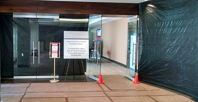NYC apartment building lobby renovation in progress with dust barriers, floor protection, and resident communication signage