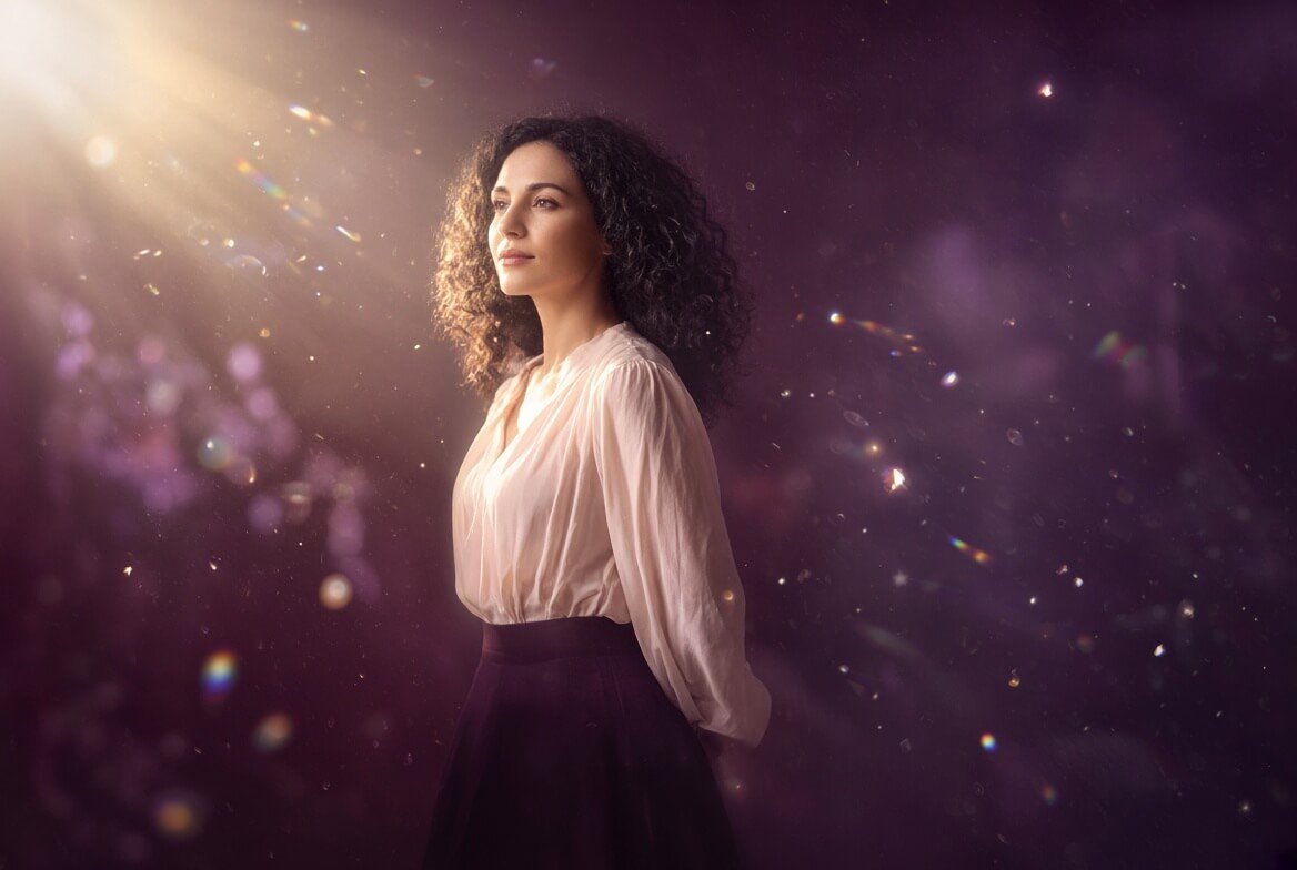 A Starseed woman stands in soft light and sparkles, representing a Starseed beginning daily spiritual practice after discovering who she is.