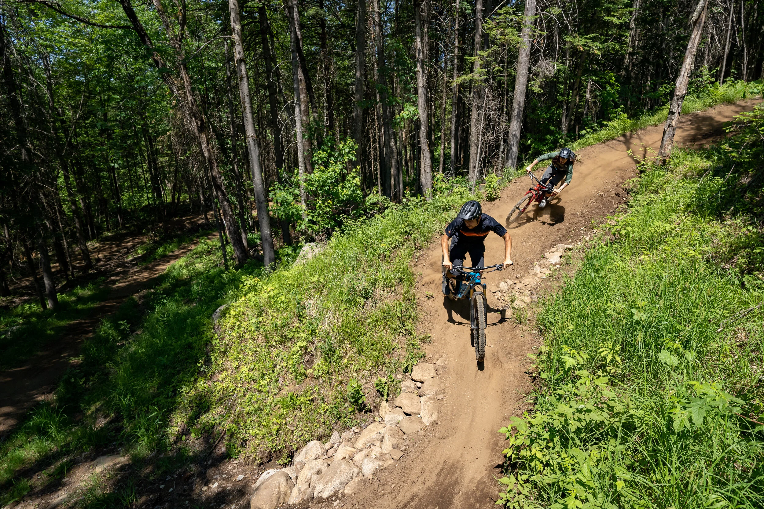 Hugo et moi négociant le dernier virage de la piste Roche-Mère. Au bas, on aperçoit la Coq-Rond qui vous mène au Mont Suisse.  // Photo Gabriel Gakwaya de MTBQC