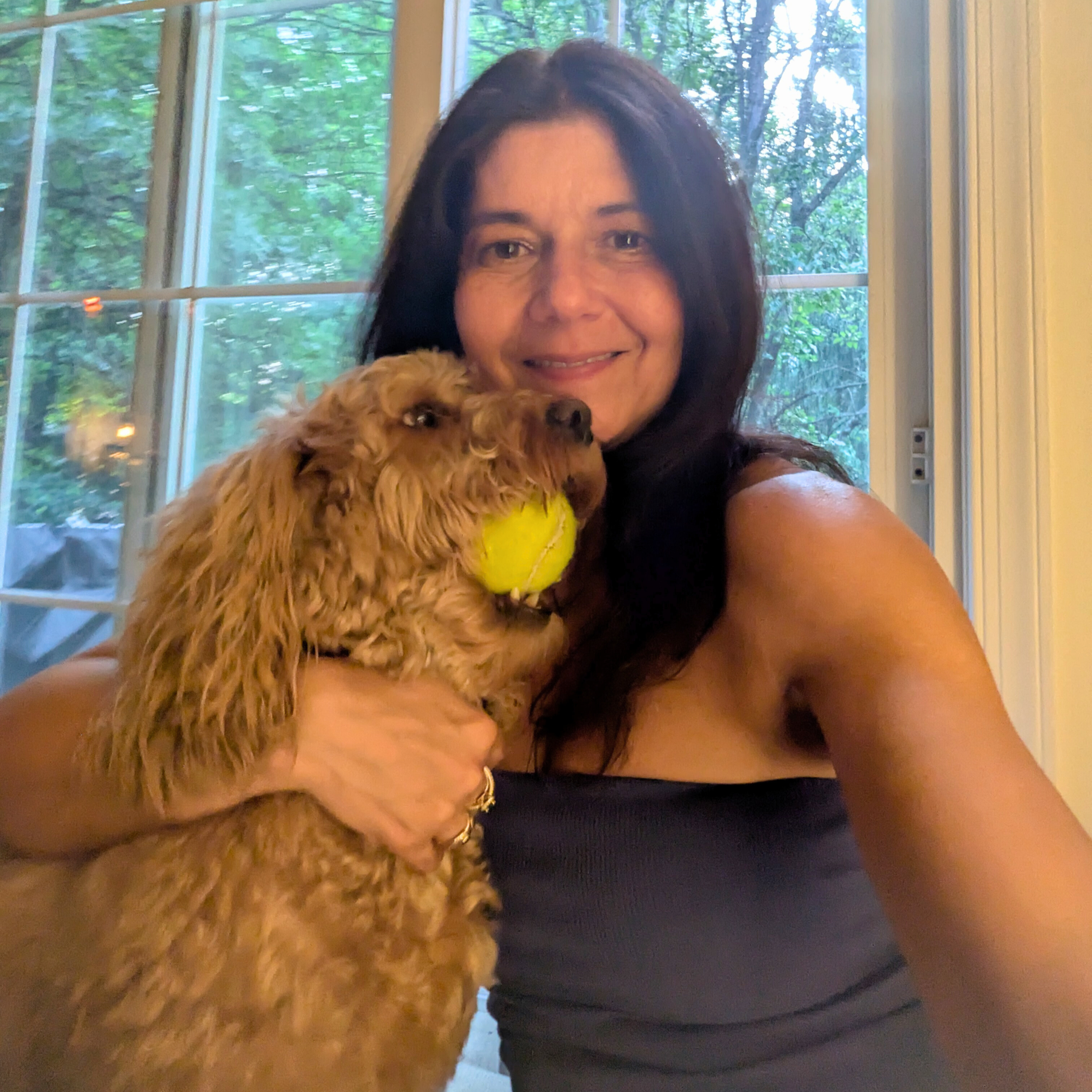 Luciana Coutinho Master Formulator, Founder of LULUBLE and SknSprk, with her dog, a mini-goldendoodle called Rocky