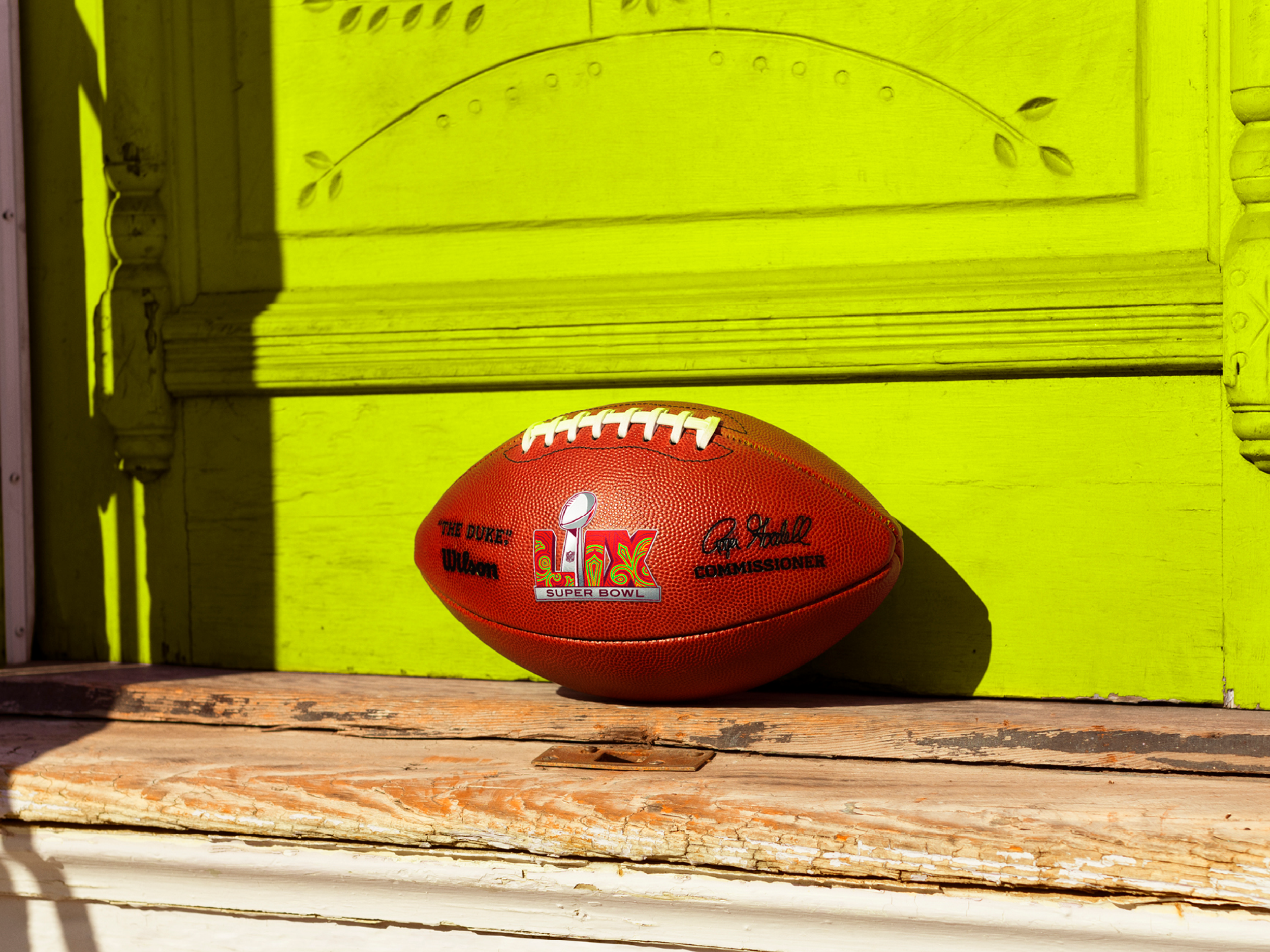 Super Bowl LIX football in front of neon green door