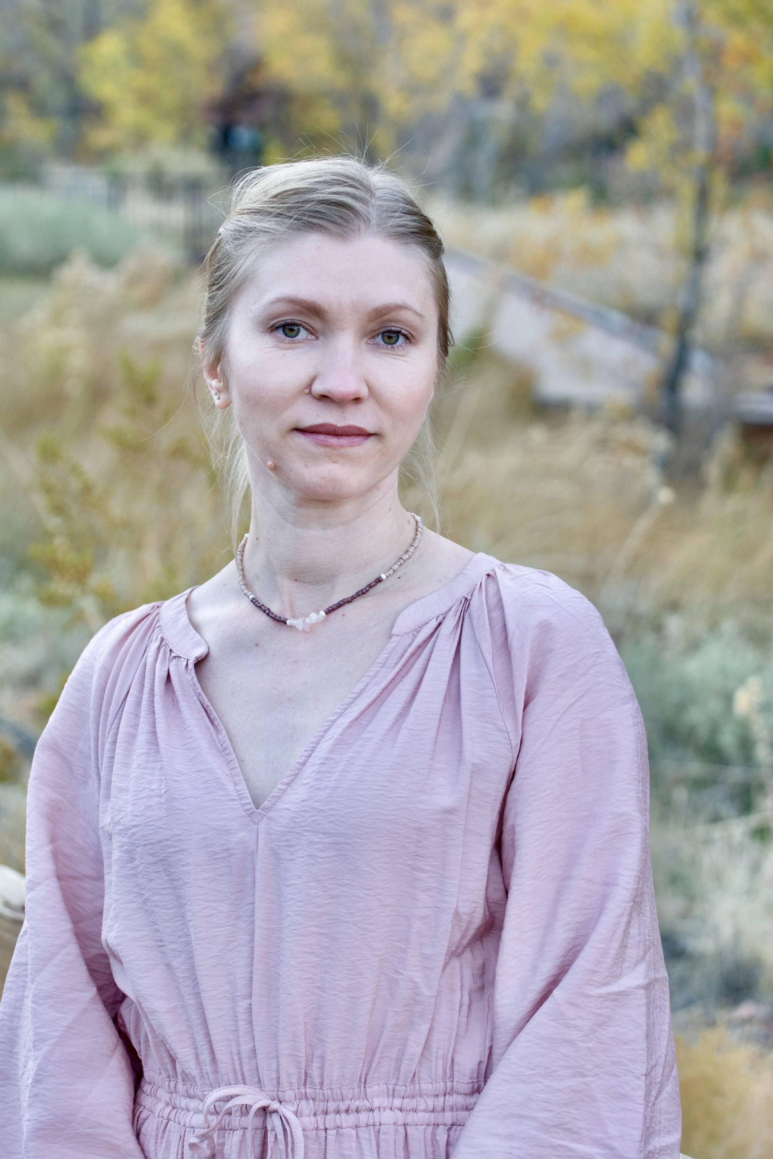 Sound healing and breathwork practitioner standing outdoors in a calm autumn landscape, representing mindfulness, emotional healing, and nervous system regulation.