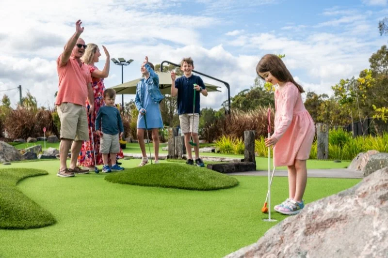 family playing mini golf