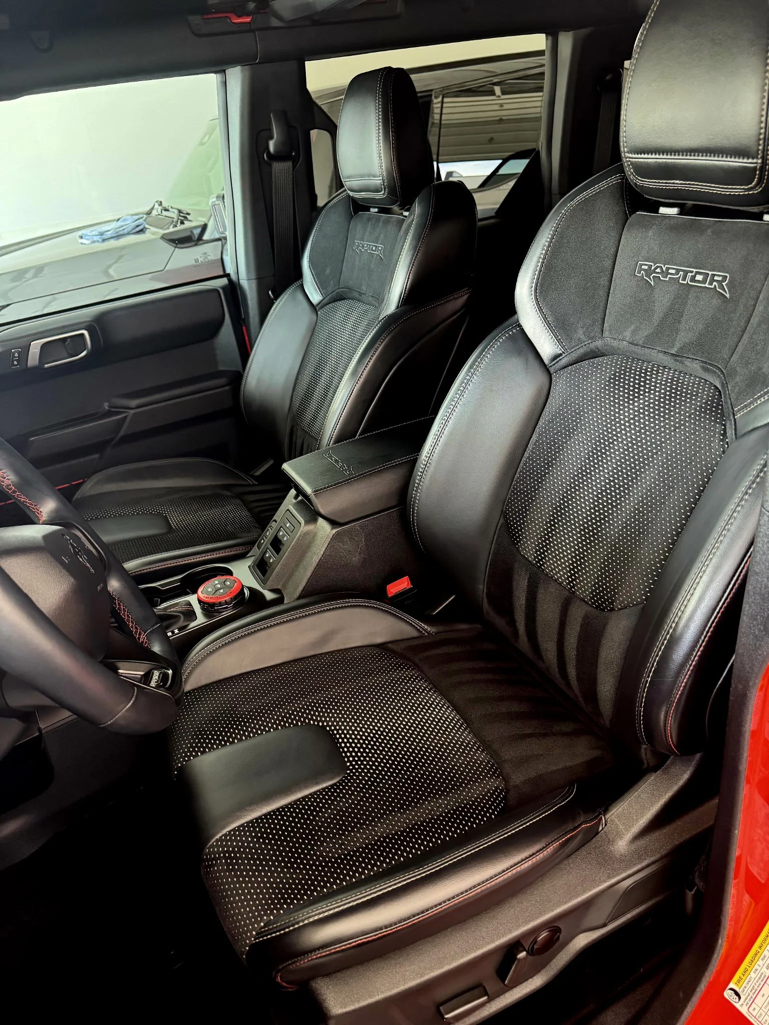The interior of a vehicle featuring two black leather seats with 