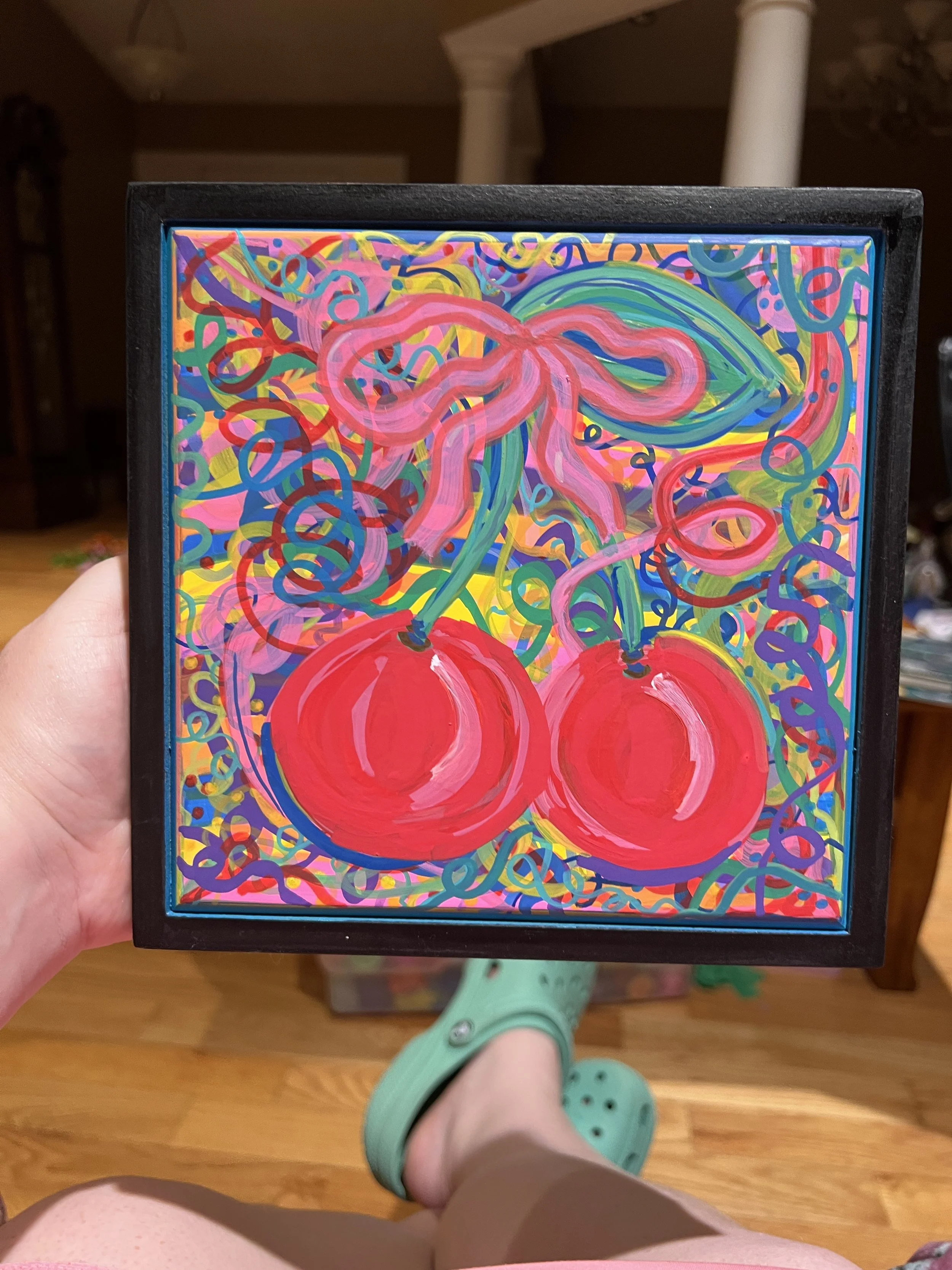 Colorful abstract painting with bright swirls, circles, and lines, featuring two large red circles at the bottom.