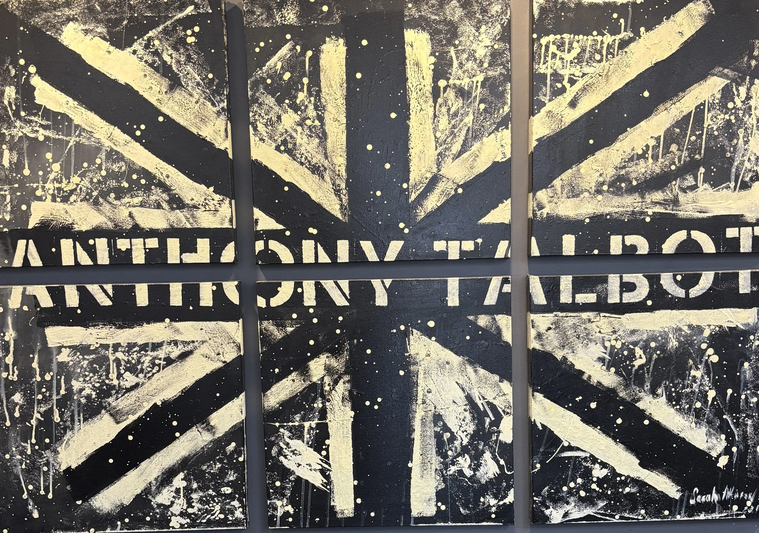Abstract painting of the British flag in black and gold with the phrase 'Anthony Talbot', splattered paint and textured brushstrokes.
