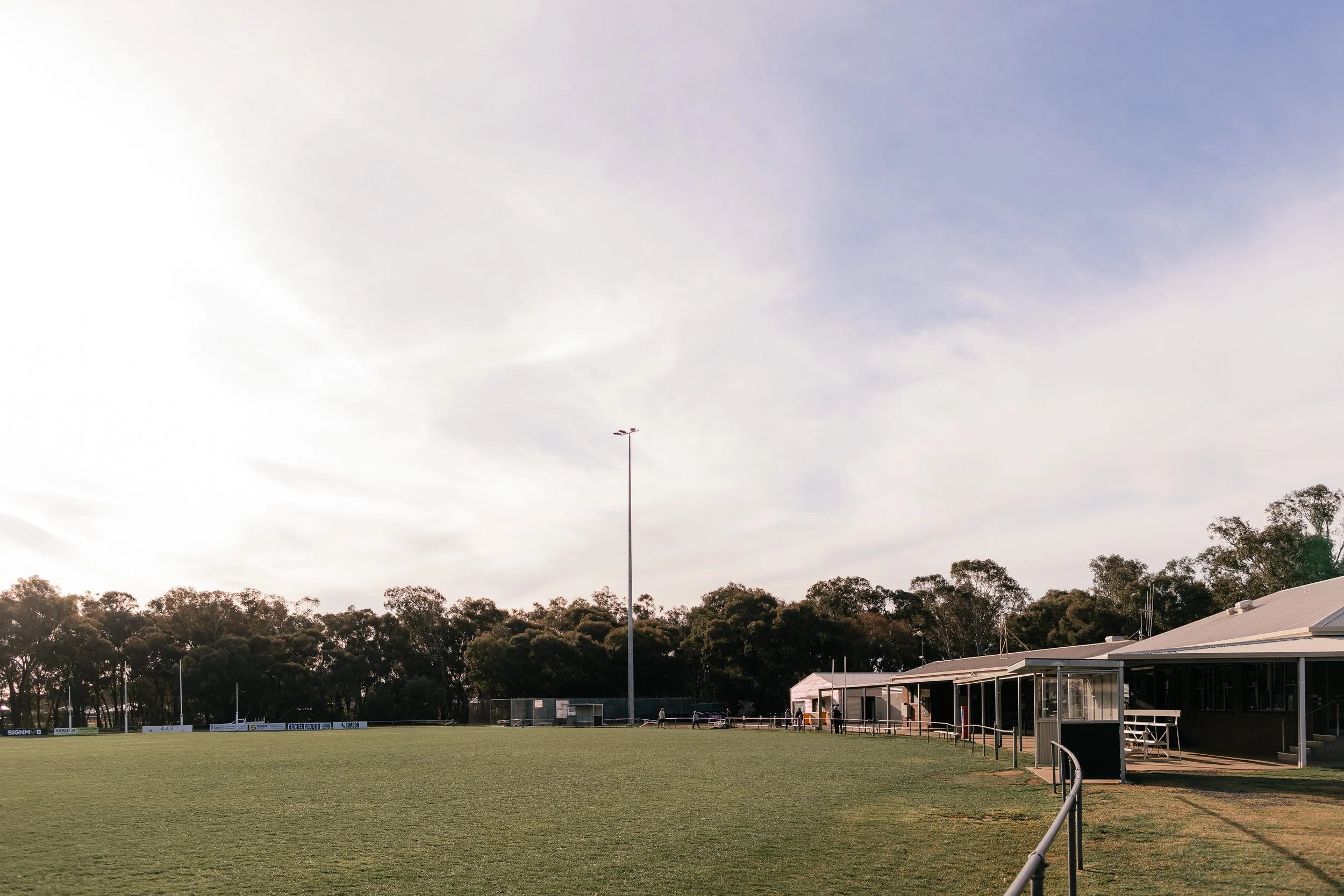 Scenic view of a mountain range with a lake in the foreground and grassy hills and shrubbery.