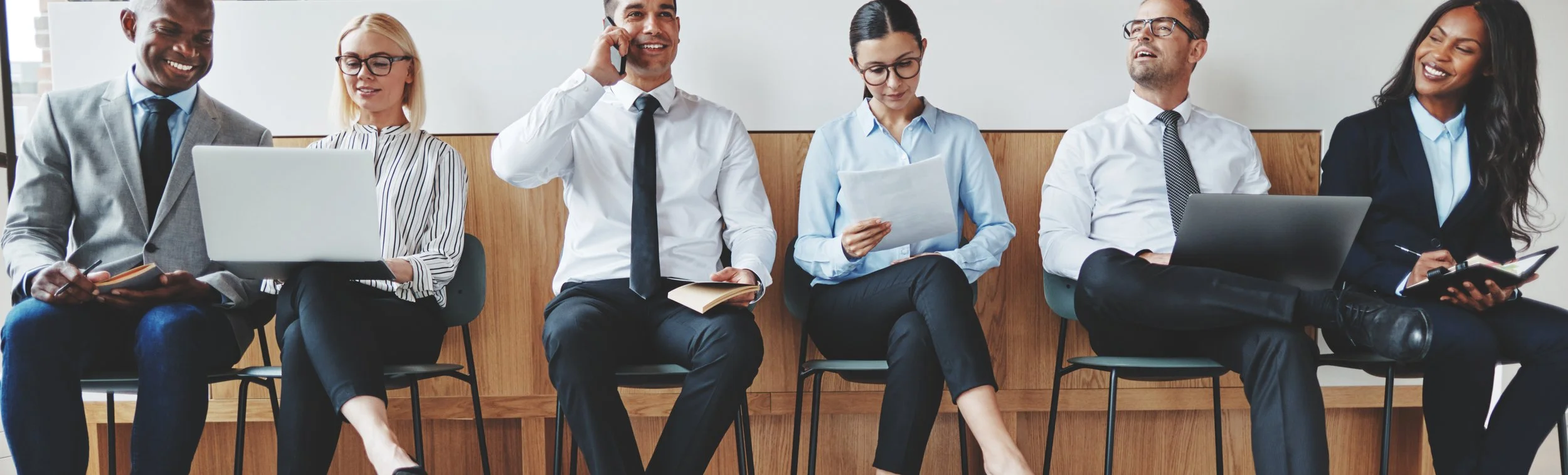 Smiling businesspeople sitting in an office working by gestaldt