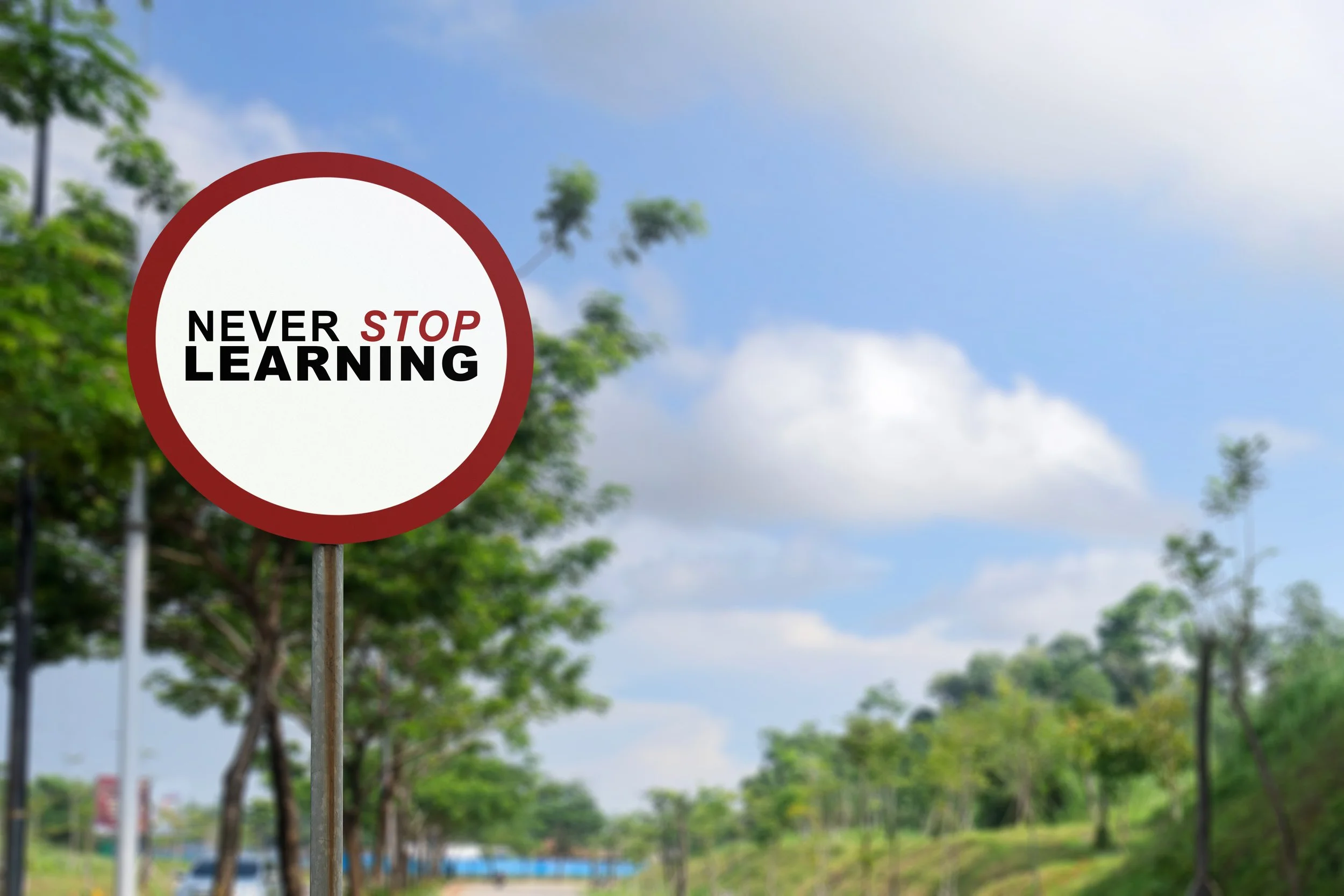 White traffic sign with text never stop learning by Gestaldt Management Development Consultants