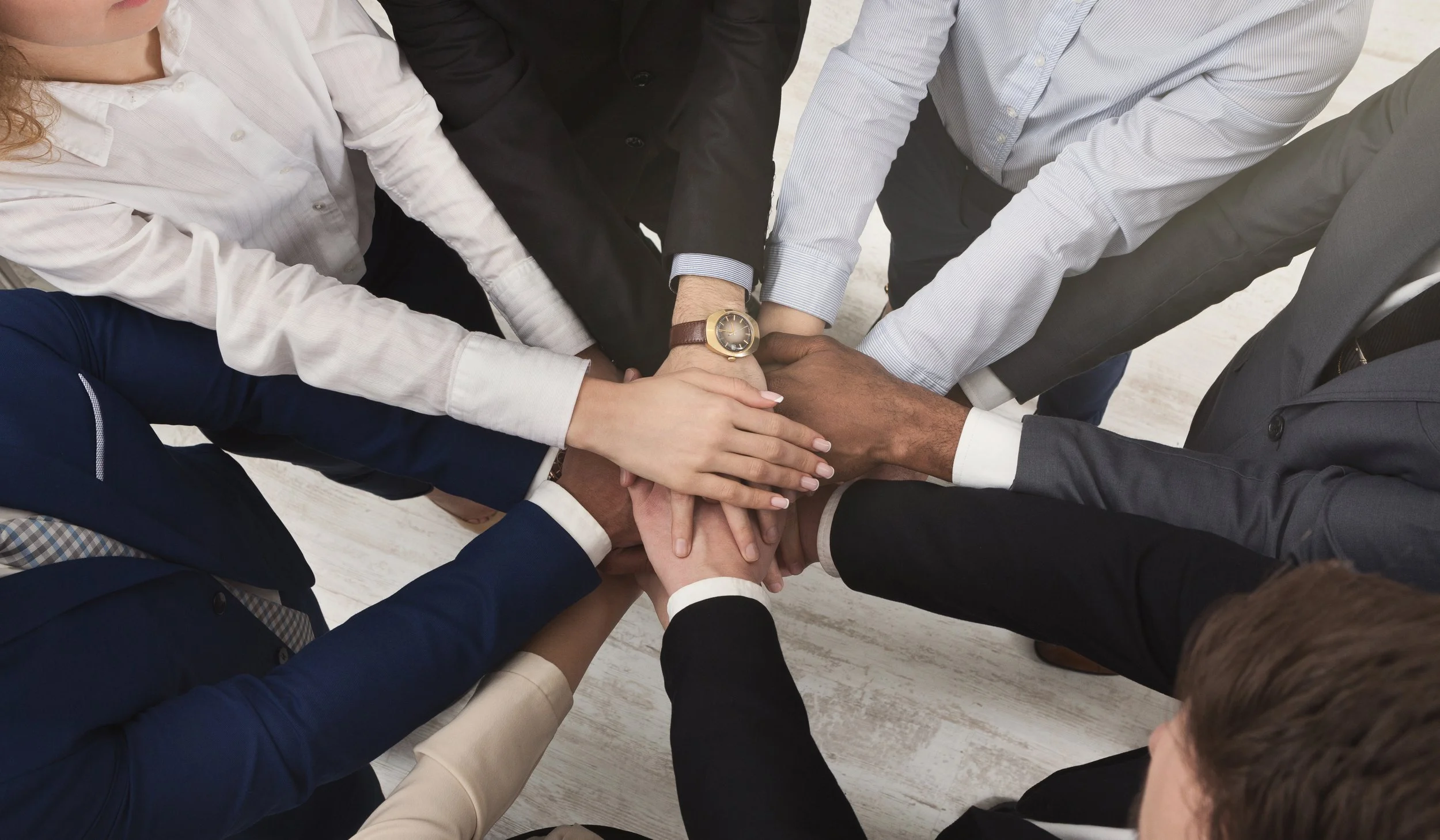 Team of united businessmen and government officials  standing with hands together by Gestaldt.