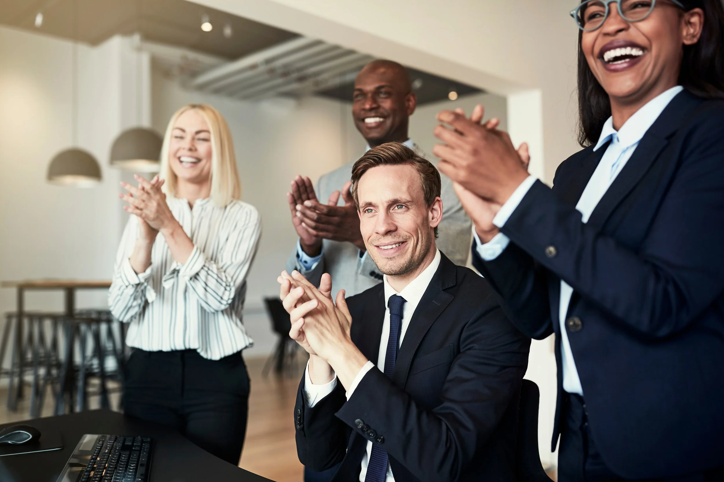 Diverse group of businesspeople clapping after an office presentation by Gestaldt Consulting Group