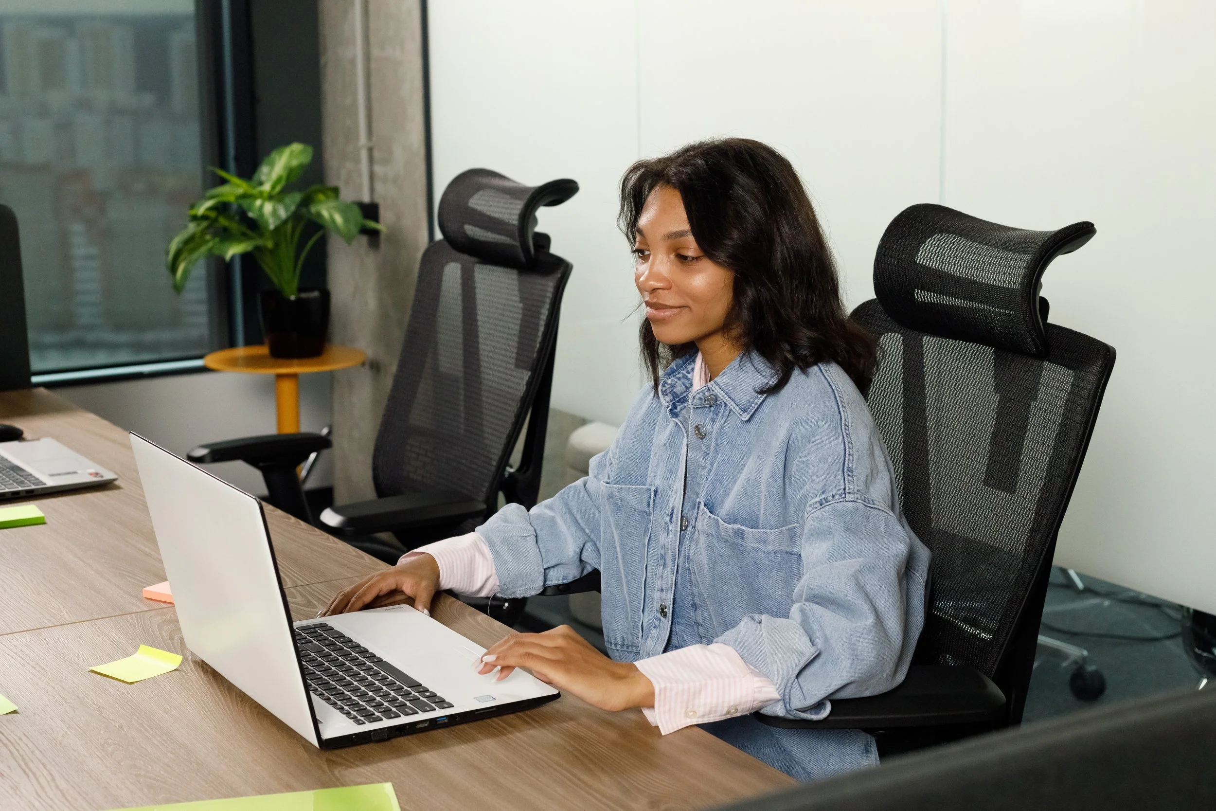 Young African business woman employee or executive manager using computer looking at laptop and talking leading hybrid conference remote video call virtual meeting by Gestaldt.