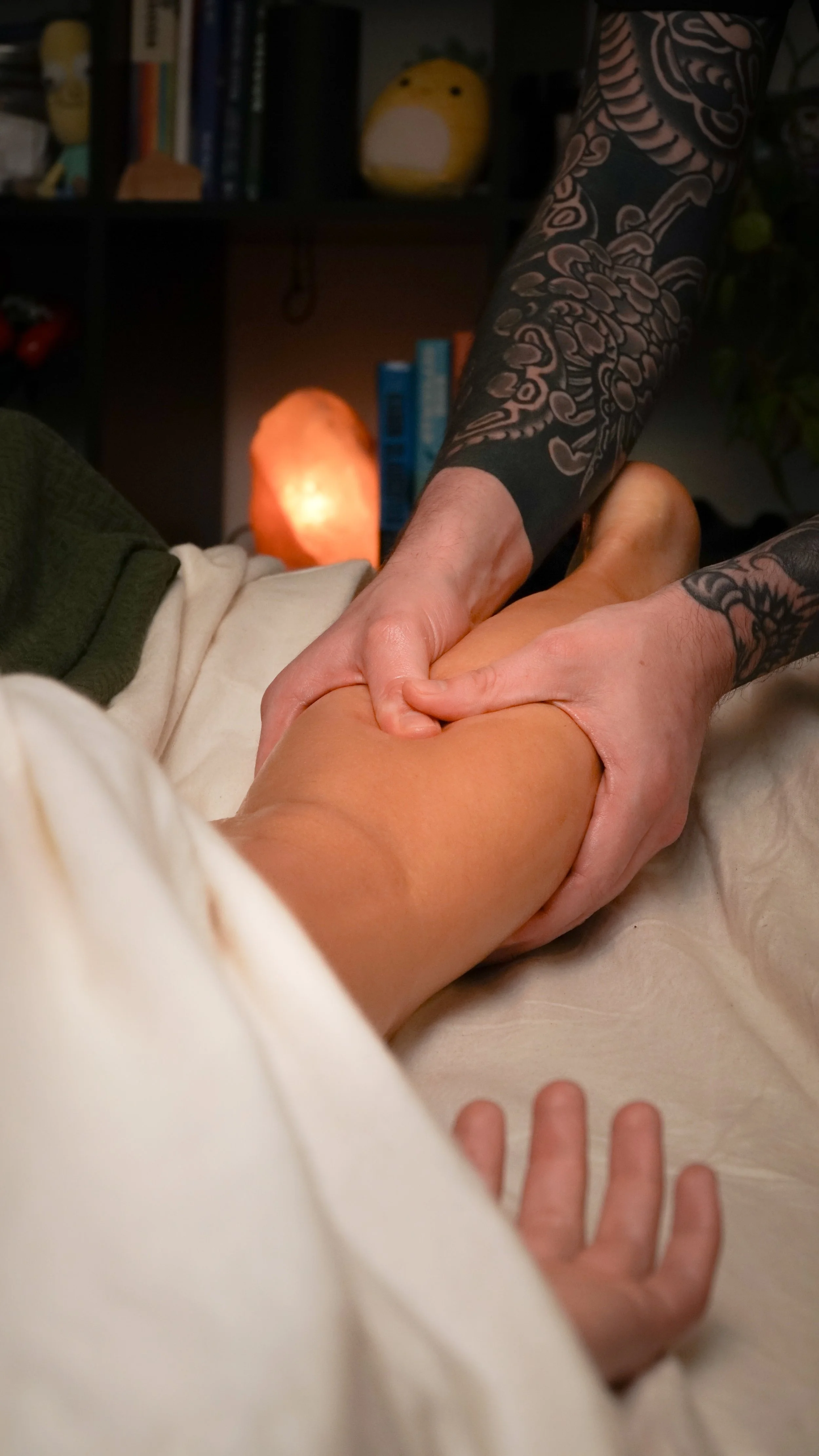 A person receiving a swedish massage on their calves.