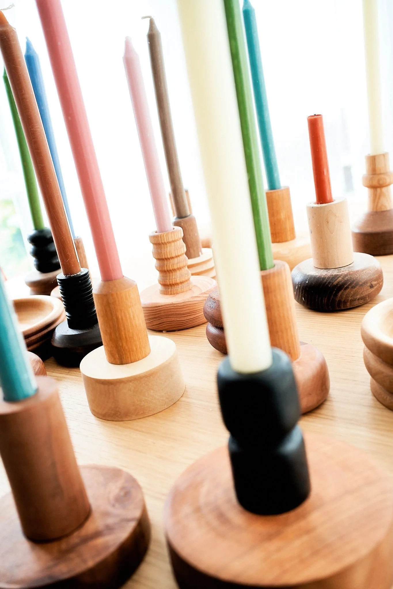 Bunte Kerzen auf Holzständern.