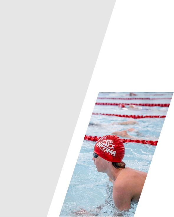 Swimmer in a red cap at a swimming pool during a race.