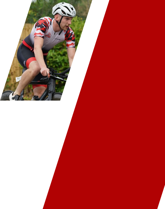 A male cyclist wearing a white helmet and cycling gear riding a mountain bike outdoors.