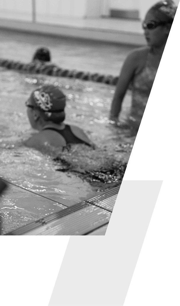 Children swimming in a pool with a female supervising.