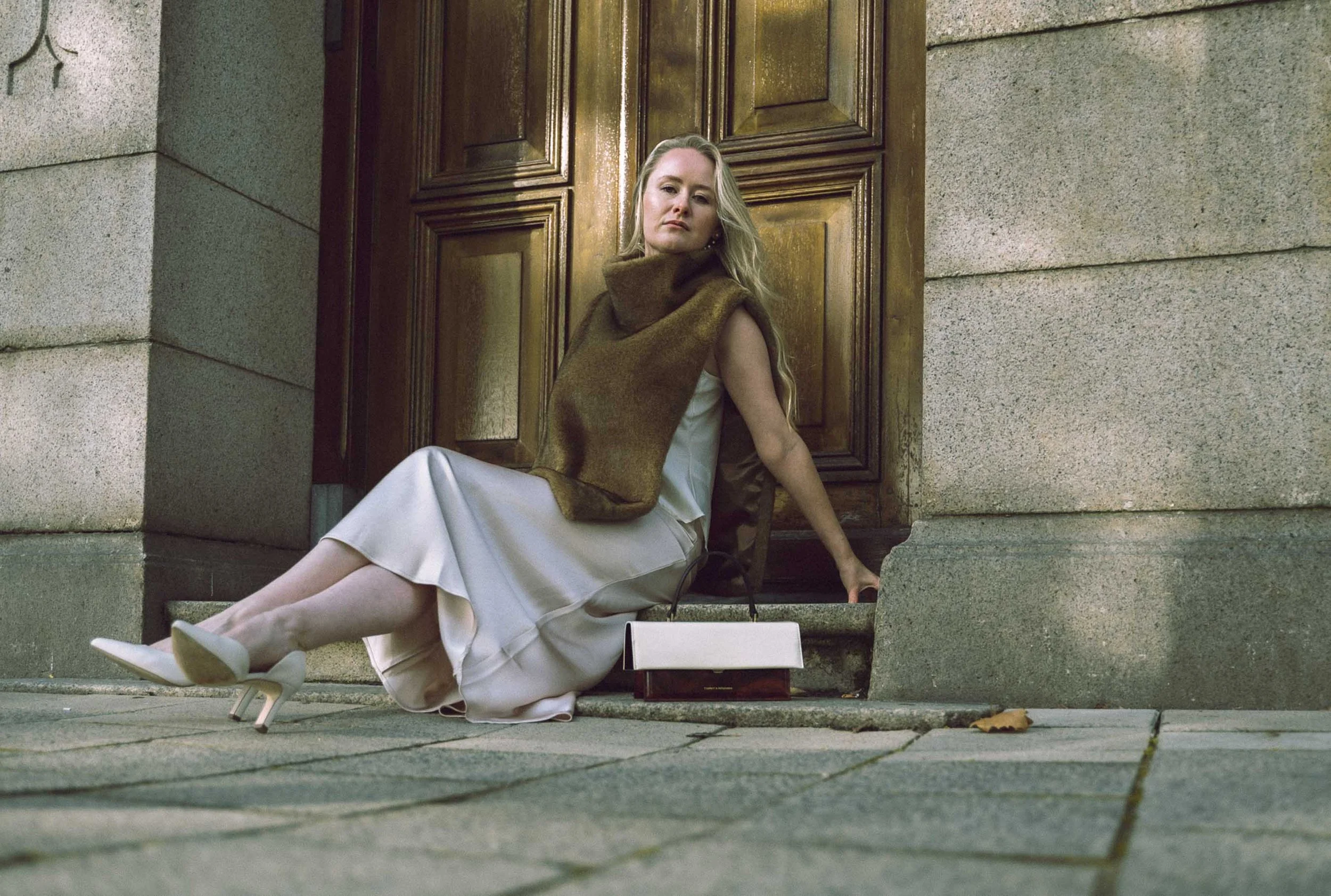 Editorial portret vrouw in elegante jurk met tas, klassieke architectuur Rotterdam