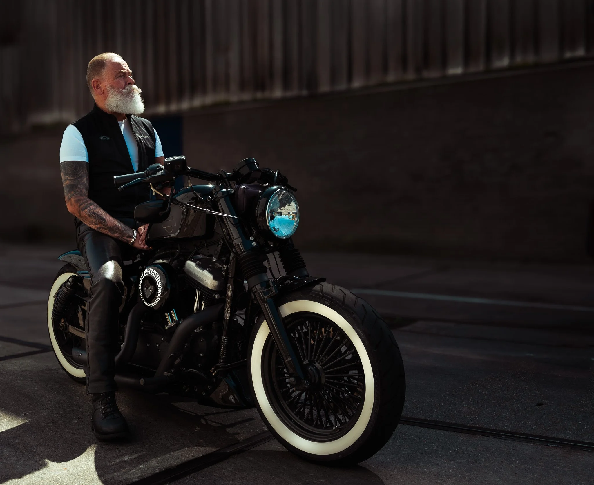 Personal branding portret van een motorrijder, zelfverzekerd geposeerd op zijn motor in Rotterdam.